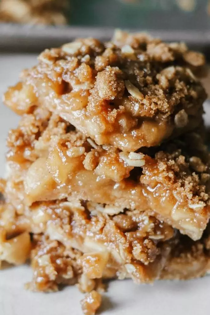 A stack of apple crisp bars sitting on a plate