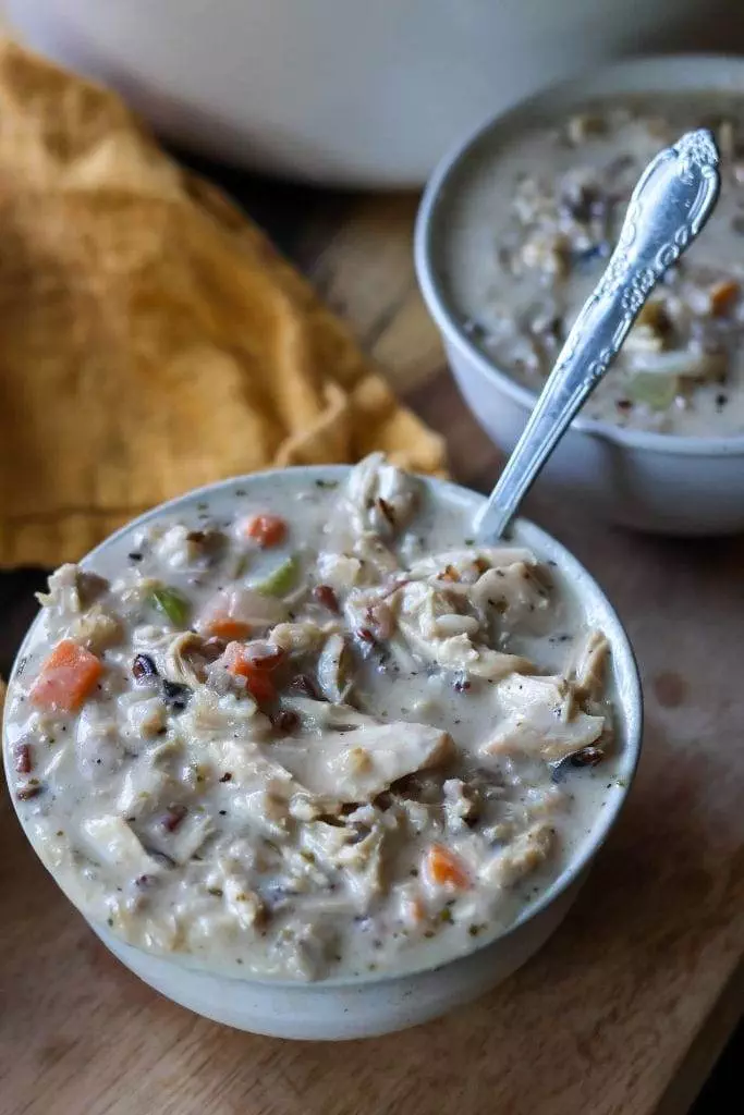 Creamy chicken and wild rice soup served in white ceramic bowl