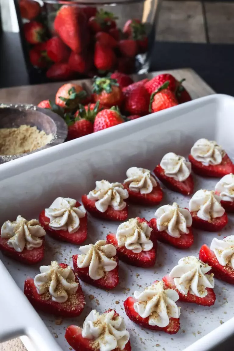 deviled strawberries filled with a smooth cheesecake mixture, topped with a sprinkle of graham cracker crumbs.