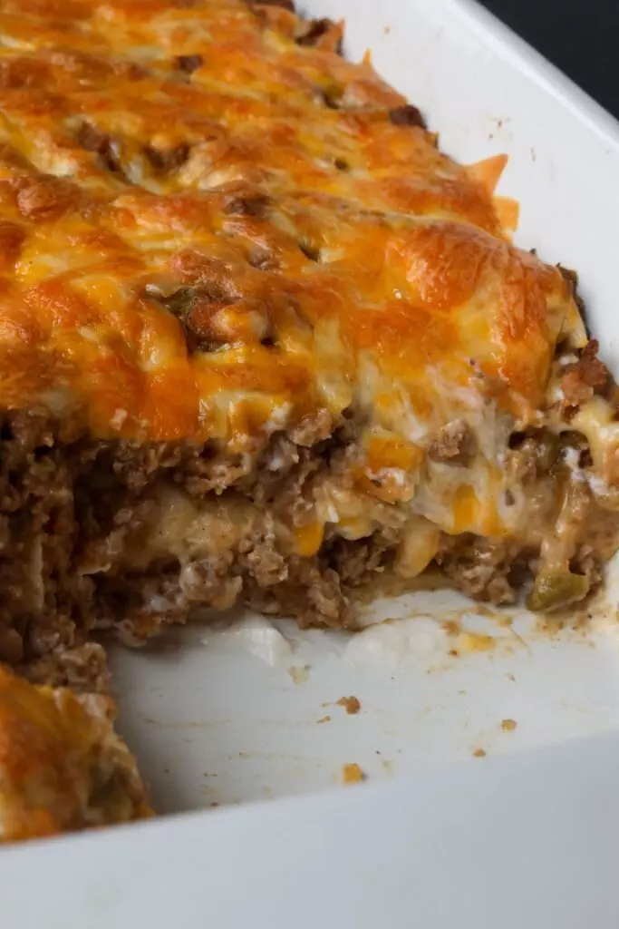 close up of creamy burrito casserole in a baking dish