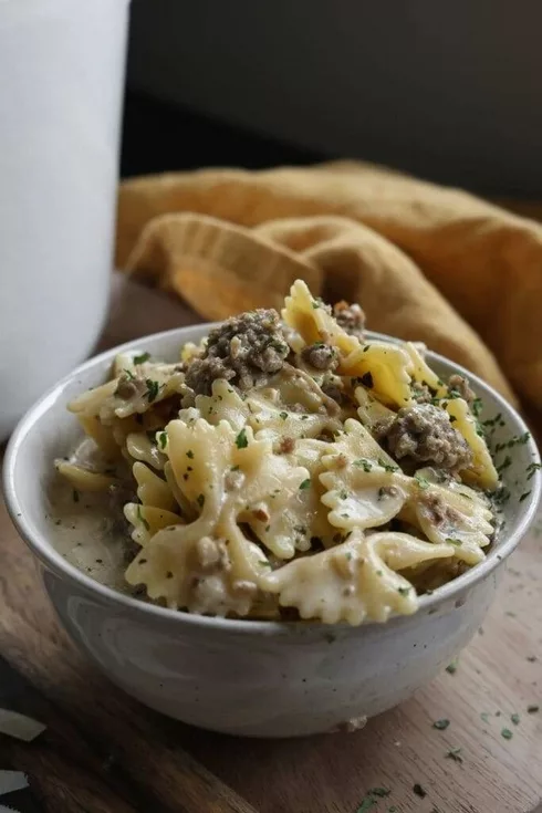 A hearty bowl of Italian sausage soup with a creamy parmesan broth, topped with grated parmesan